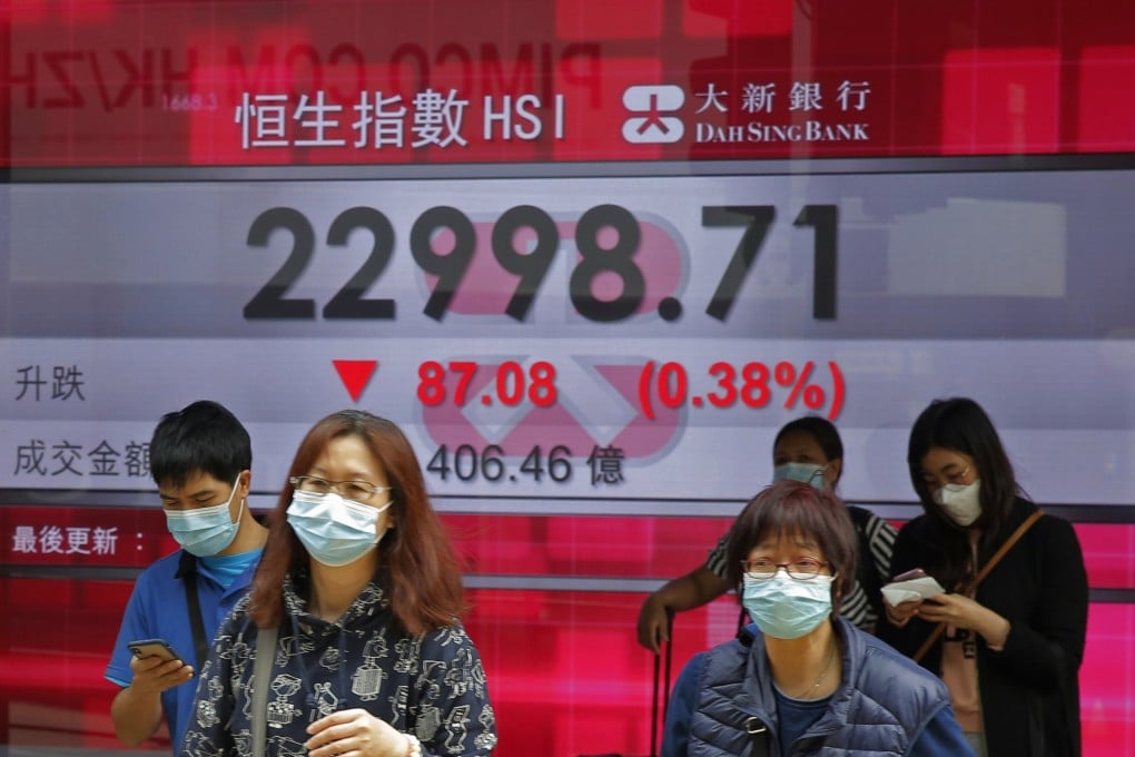 People walk past an electronic board showing Hong Kong share index outside a local bank in Hong Kong, on April 2, 2020. Photo: AP