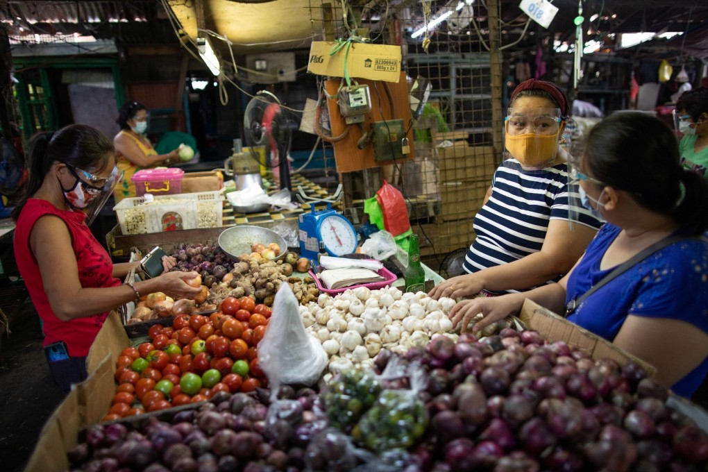 Vendors chat at a public market in Rizal province, in the Philippines. Government relief programmes have assisted those who temporarily lost their livelihoods because of the Covid-19 lockdowns. Photo: Reuters