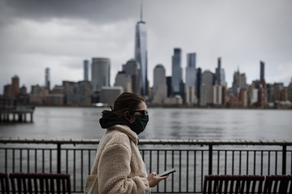 A woman walks along the Jersey City waterfront with the New York City skyline in the background in April. The White House declared the pandemic a national emergency on March 13. Photo: AP