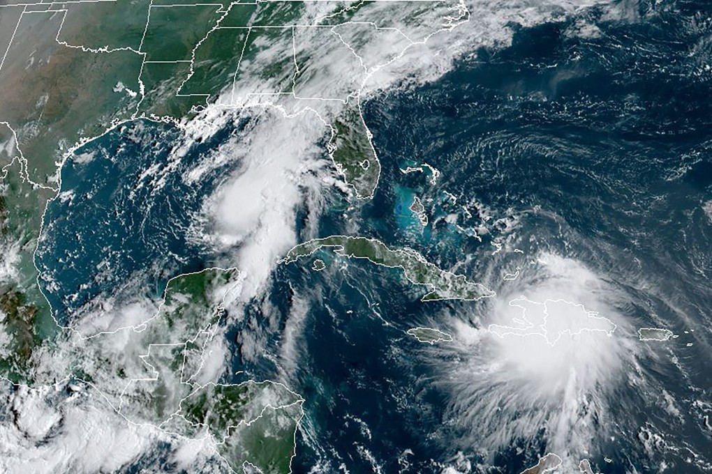 This satellite image shows Tropical Storm Laura moving over Haiti and the Dominican Republic in the Caribbean as a second storm, named Marco (upper left), moves into the Gulf coast on Sunday. Image: RAMMB/NOAA via AFP
