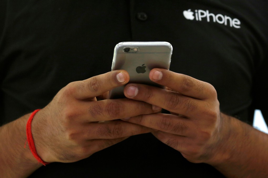 A salesman uses his iPhone at a mobile phone store in New Delhi, India. The country’s 1.3 billion people represents a large, underserved smartphone market that is becoming an increasingly important focus for Apple. Photo: Reuters