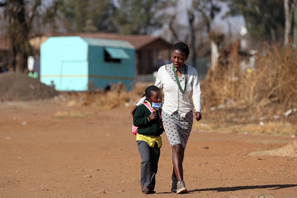 A woman walks with her daughter on Monday in Eikenhof, south of Johannesburg, where schools have reopened. After a surge in coronavirus cases, South Africa’s health minister says “the plateau has started”. Photo: Reuters