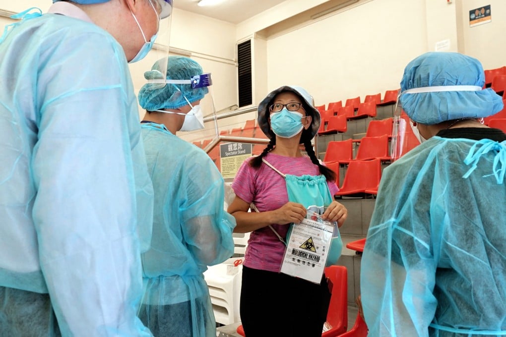 A Hong Kong resident receives a Covid-19 testing kit in Sai Kung. Photo: Felix Wong