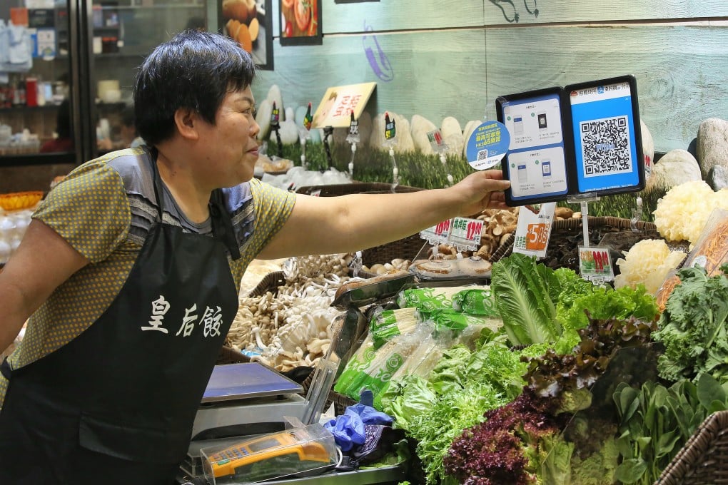 Mrs Yim shows the merchant quick response (QR) code and payment instructions for Ant Group's Alipay service at her stall at Po Tat Market in Hong Kong’s Sau Mau Ping on 18 November 2017. Photo: Edmond So