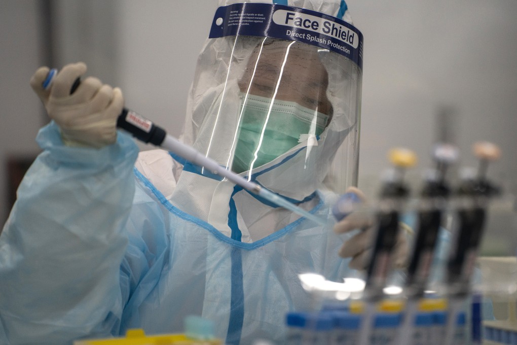 A technician in a protective suit processes RT-PCR Covid-19 tests at a laboratory in Hong Kong on July 31. Photo: Bloomberg