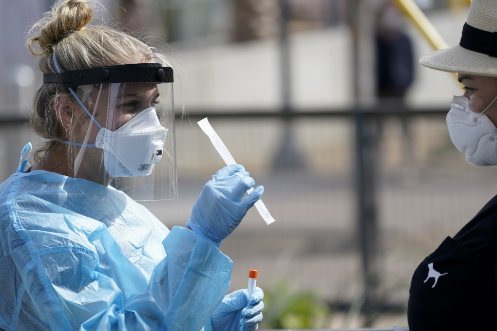 Nurse practitioner Debbi Hinderliter collects a sample from a woman at a coronavirus testing site in San Diego. Photo: AP