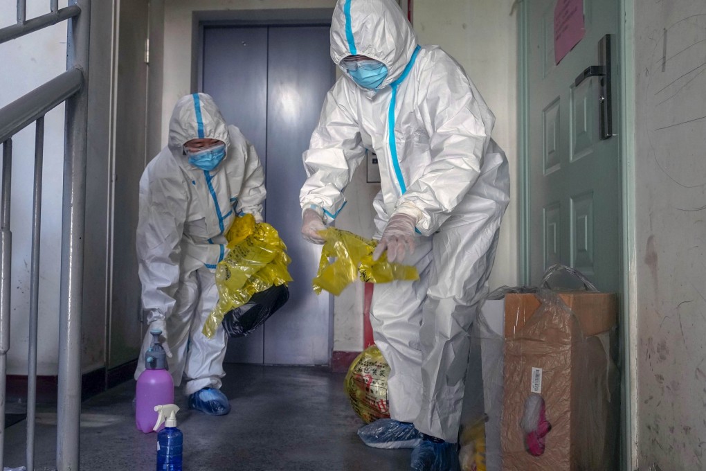 Volunteers collect rubbish from quarantined households in the Tianshan district of Urumqi in Xinjiang. Photo: Xinhua