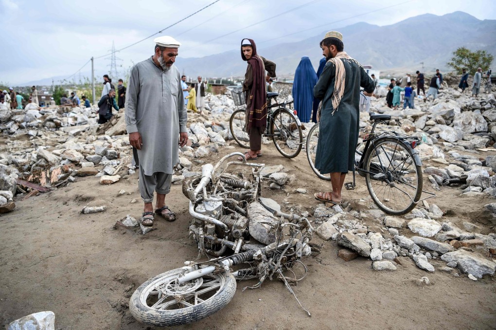 Residents gather among debris after a flash flood affected the area at Sayrah-e-Hopiyan in Charikar, Parwan province. Photo: AFP