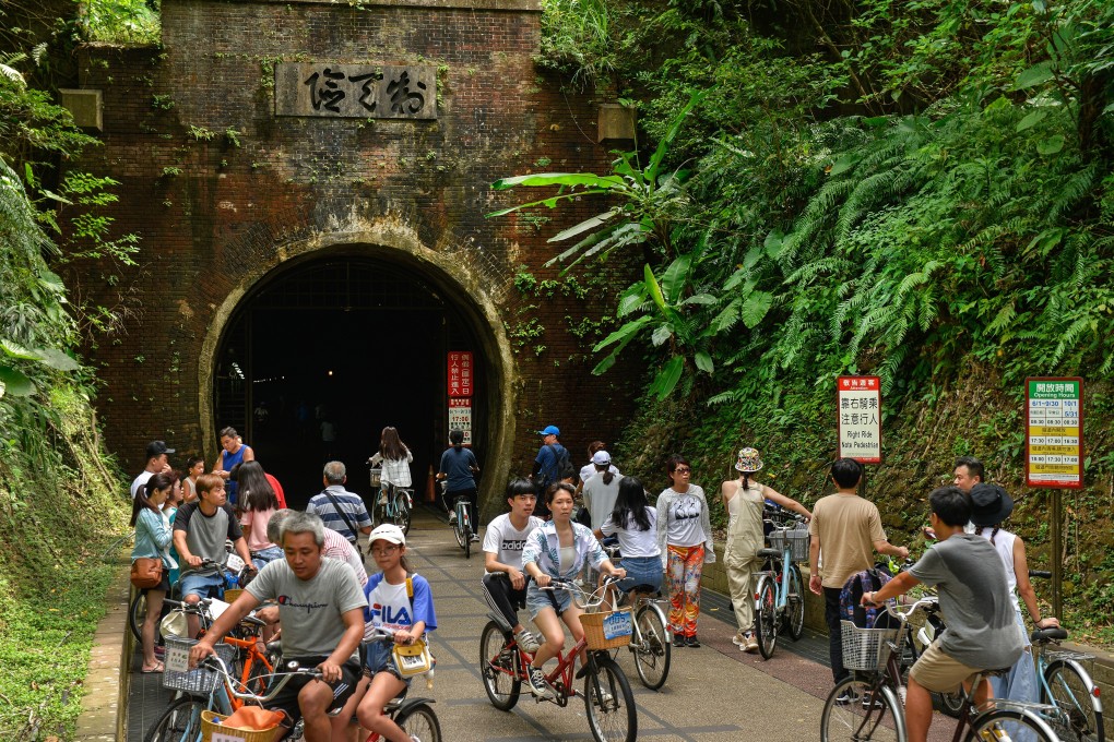 Cyclists at the Fulong end of the disused Caoling railway tunnel in Taiwan. It has become a magnet for holidaymakers unable to travel abroad this summer because of Covid-19. Photo: Chris Stowers /Panos