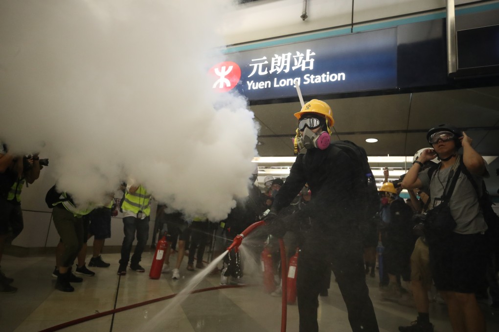Protesters use fire extinguishers and a fire hose against riot police at Yuen Long MTR Station, one month after the July 21, 2019 mob attack. Photo: Winson Wong