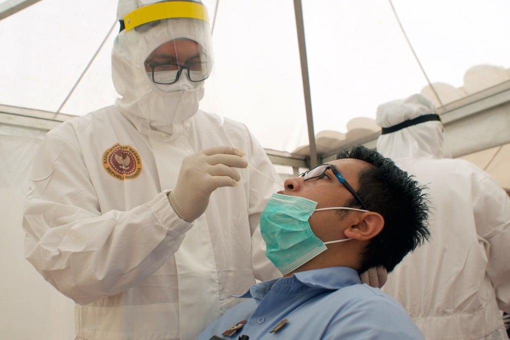 A health care worker in protective gear collects a sample during a Covid-19 swab test in Jakarta. A mutation of the virus, which was identified in February, has been circulating in Europe and the Americas before arriving in Southeast Asia. Photo: EPA-EFE