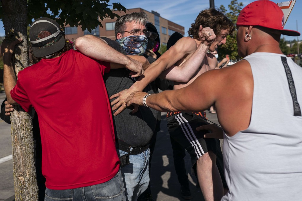 A Black Lives Matter protester scuffles with attendees of a pro-Trump rally during in Oregon on Saturday. Photo: AFP