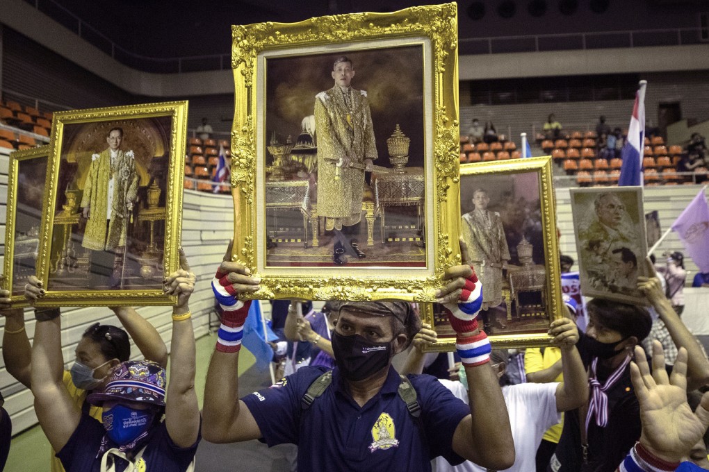 Supporters of the Thai monarchy hold up images of King Maha Vajiralongkorn and the late King Bhumibol Adulyadej during a rally in Bangkok on Sunday. Photo: AP