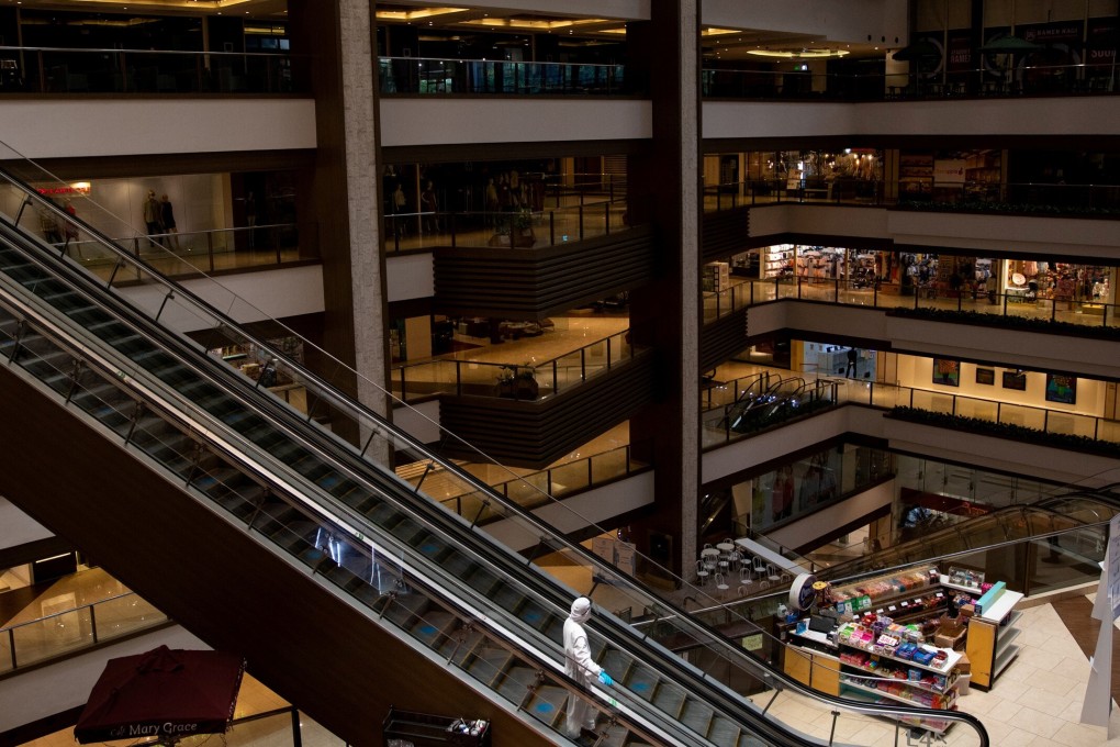 A janitor wears a hazmat suit to prevent the spread of Covid-19 in an almost empty shopping mall in Mandaluyong City, Metro Manila. Photo: Reuters