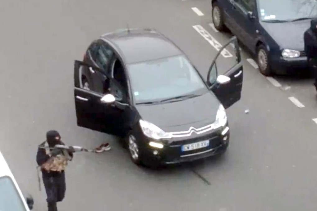 Hooded gunmen Cherif Kouachi and his brother Said aim Kalashnikov rifles towards a police officer outside Charlie Hebdo’s Paris offices in this 2015 file photo. Photo: Jordi Mir/AFP