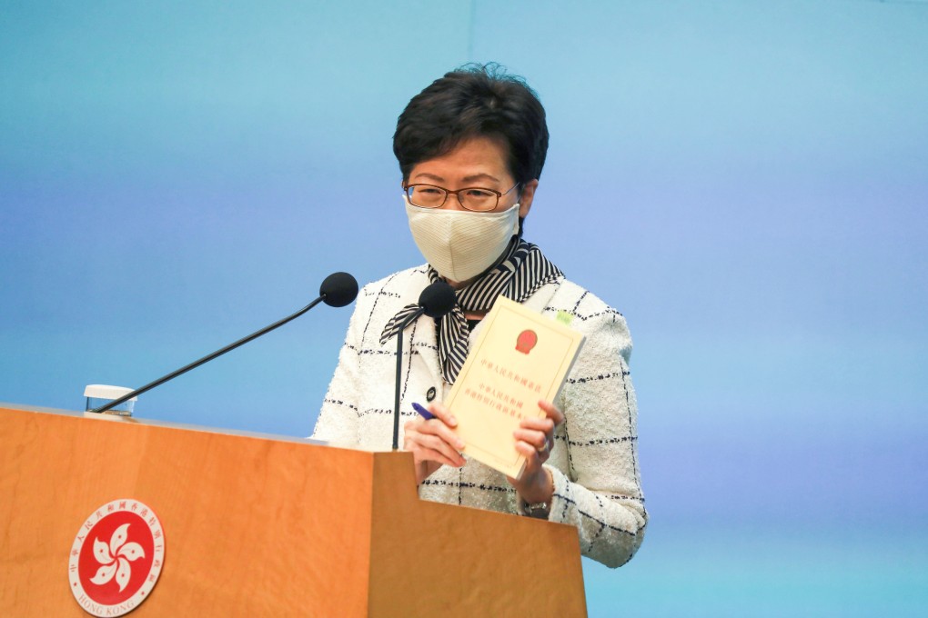 Carrie Lam holds a copy of the Basic Law during a press conference at Tamar on Tuesday. Photo: Nora Tam