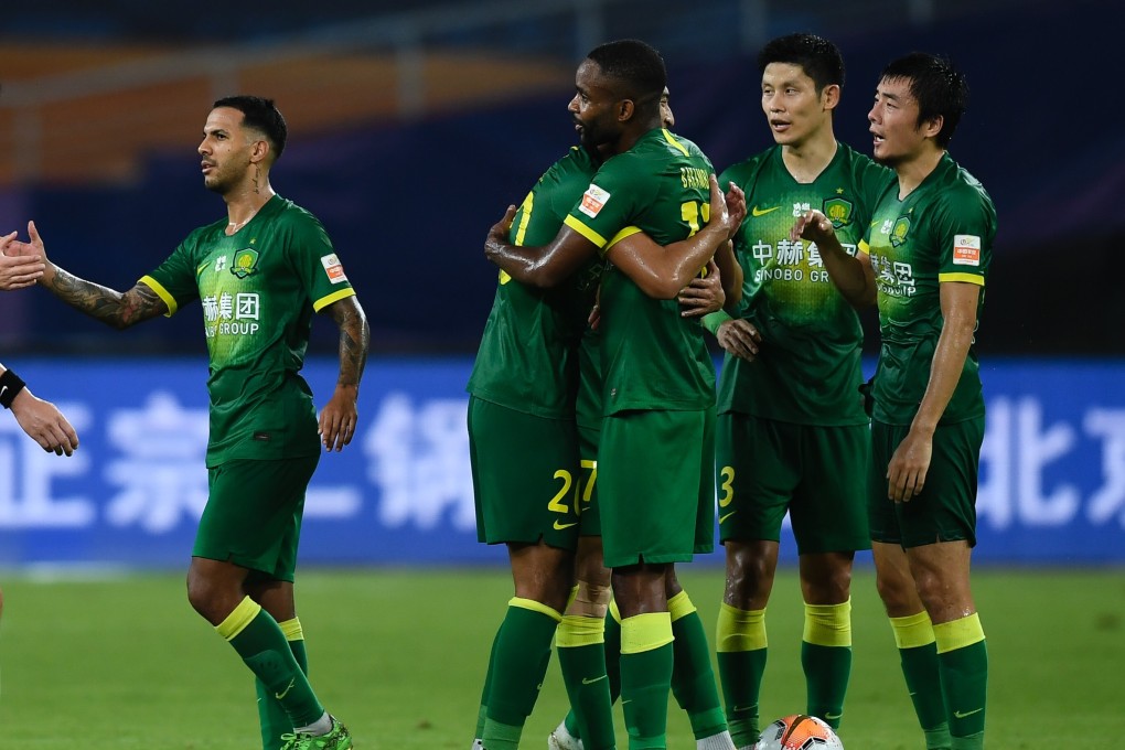 Beijing Guoan players congratulate Cedric Bakambu (centre) on scoring in the Chinese Super League. Photo: Xinhua