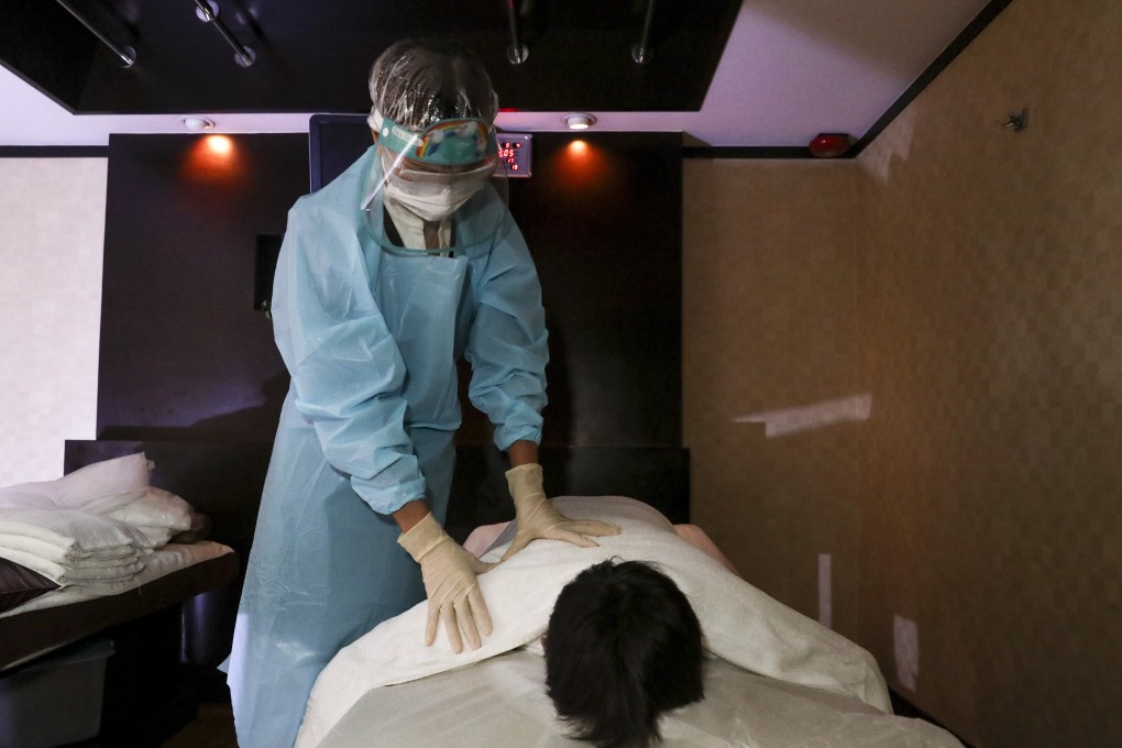 A staff member wears protective gear while massaging a customer at The Sauna & Spa in Tsim Sha Tsui. Photo: Edmond So