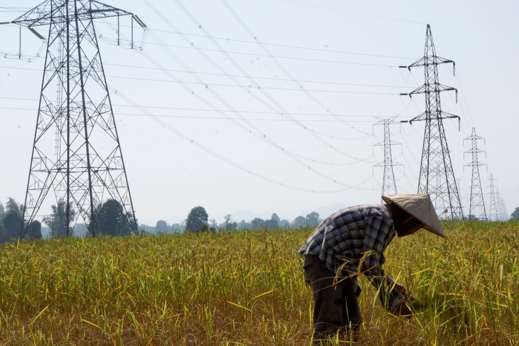 A farmer works in a paddy field under power lines in Laos’ Khammouane province in this 2013 file photo. Photo: Reuters