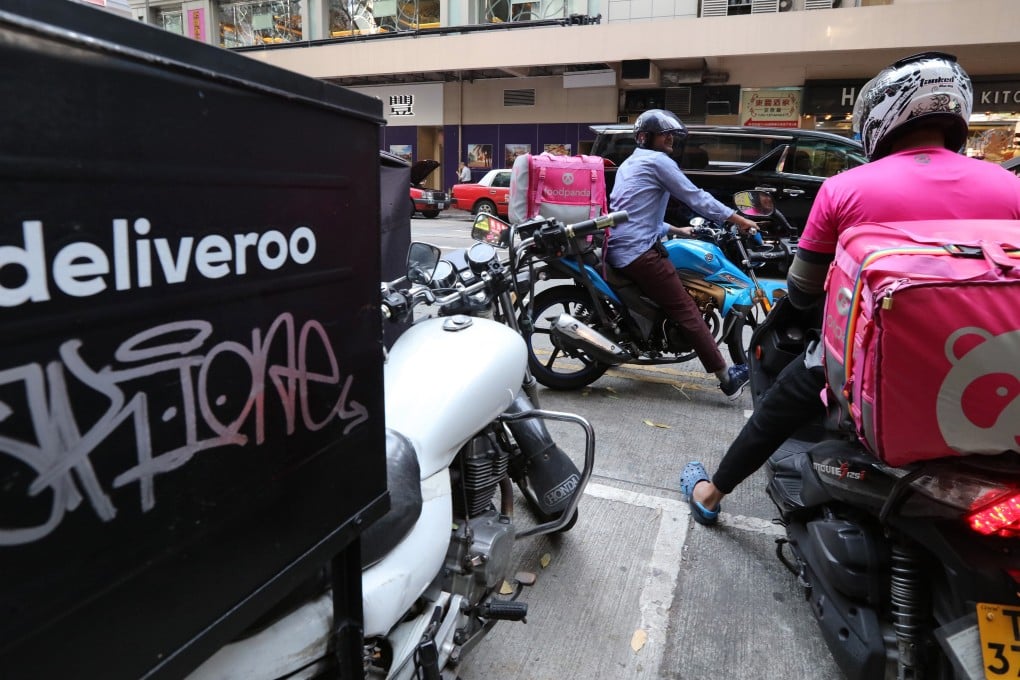 Food delivery workers prepare to take out some orders from a restaurant in Wan Chai. Photo: Felix Wong