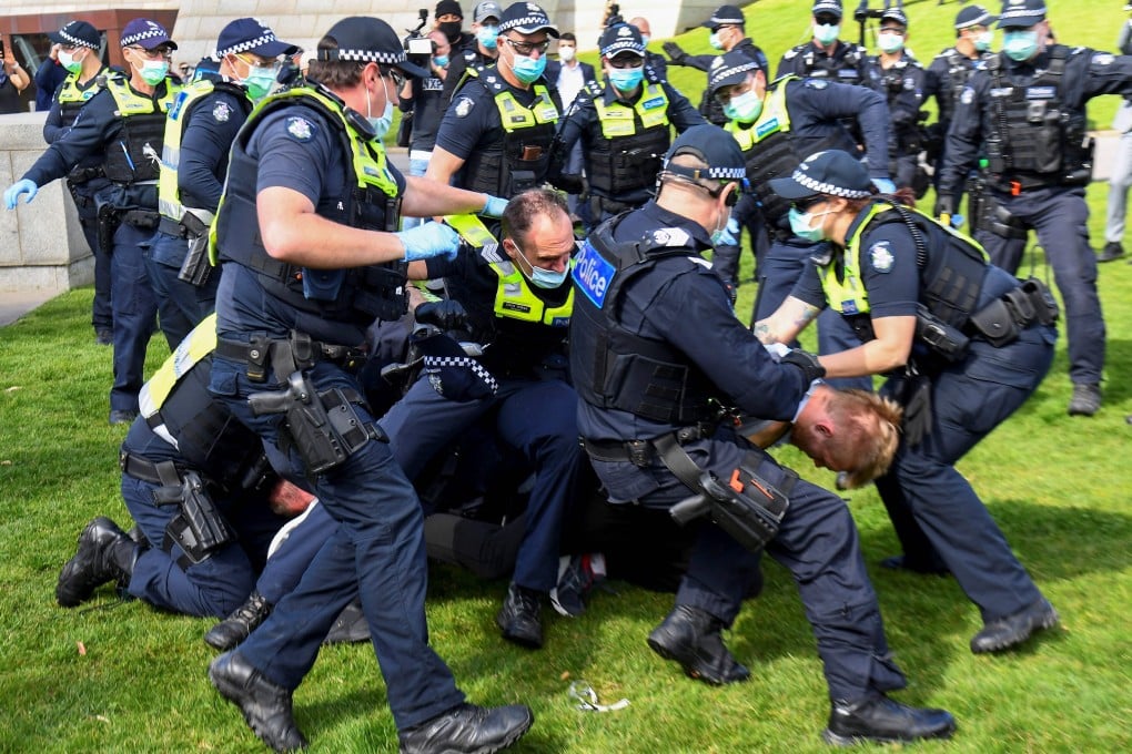 Police tackle protesters in Melbourne during a rally protesting against the state's strict lockdown laws. Photo: AFP