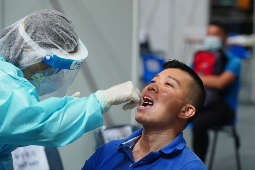 Health care professionals take a sample from a man at a centre in Queen Elizabeth Stadium in Wan Chai on September 1 as part of Hong Kong’s universal community testing programme. Photo: Sam Tsang