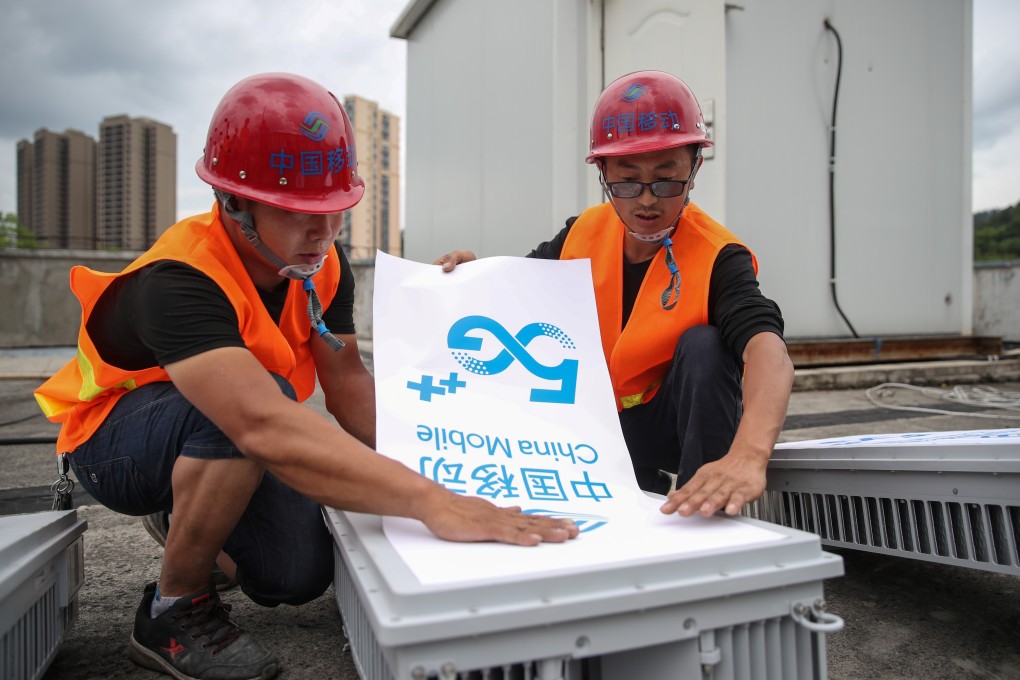 Workers place a China Mobile 5G sign as they install a 5G network base station in Fenggang, Guizhou province, China on May 26, 2020. Photo: Reuters