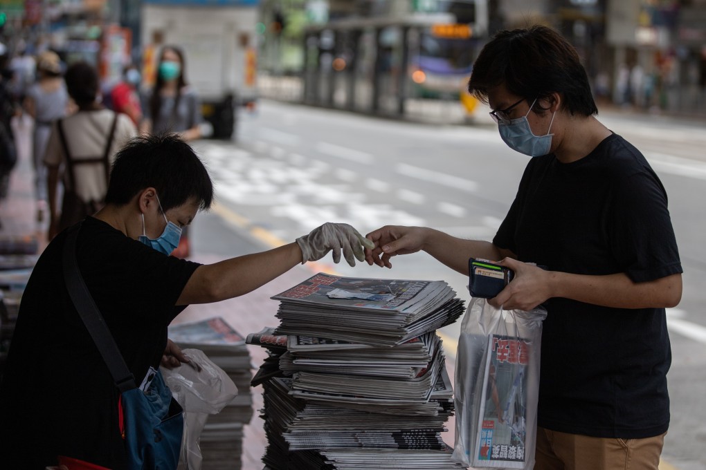 A person buys a copy of Apple Daily at a news stand in Hong Kong on August 11, after the arrest of the newspaper’s founder, Jimmy Lai Chee-ying, under the national security law. Photo: EPA-EFE