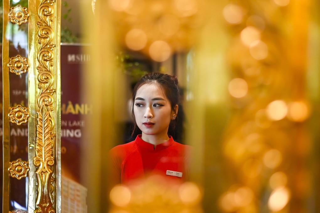 A staff member waits to welcome guests in the lobby of the newly inaugurated Dolce Hanoi Golden Lake hotel, the world's first gold-plated hotel, in Hanoi on July 2. From an investor perspective, gold has been a safe haven for thousands of years. Photo: AFP