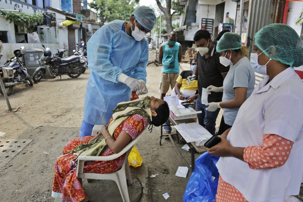 A health worker takes a nasal swab sample to test for Covid-19 in Ahmedabad, India. The country leads the world in new infections. Photo: AP