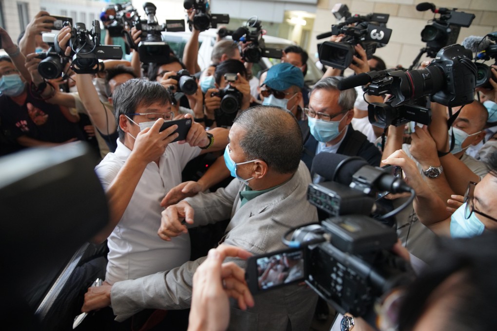 Apple Daily founder Jimmy Lai navigates a crowd of journalists outside West Kowloon Court on Thursday after being found not guilty of intimidating a reporter from a rival newspaper. Photo: Winson Wong