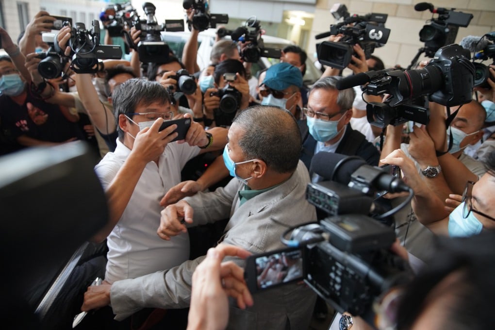 Apple Daily founder Jimmy Lai navigates a crowd of journalists outside West Kowloon Court on Thursday after being found not guilty of intimidating a reporter from a rival newspaper. Photo: Winson Wong