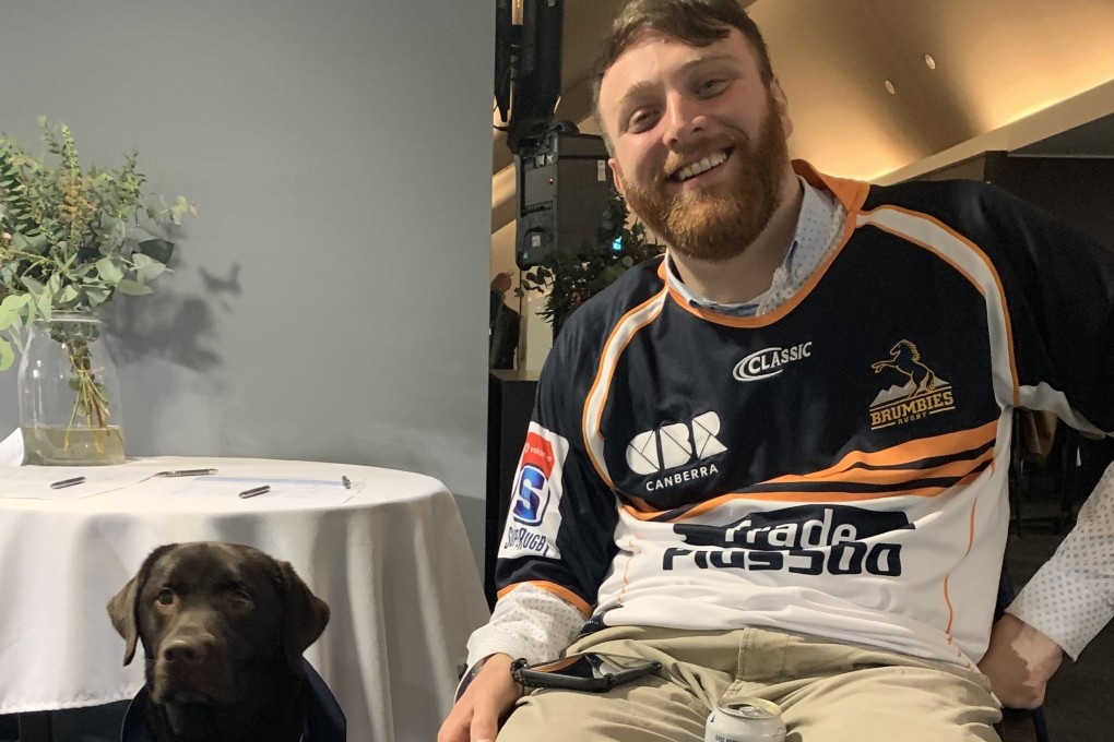 Ben Kende with his assistance dog Gumnut. The tetraplegic said he’s quite happy with his life 10 years after his rugby accident. Photo: Handout