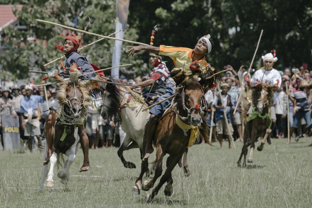 A rider throws a blunt wooden spear at an opponent during Pasola, a ritual war game played on the Indonesian island of Sumba. Photo: Agoes Rudianto