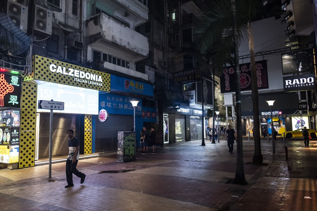 Pedestrians walk past closed stores on Russell Street in the Causeway Bay, Hong Kong. The Covid-19 pandemic has slammed tourist arrivals and retail sales for almost two years. Photo: Bloomberg