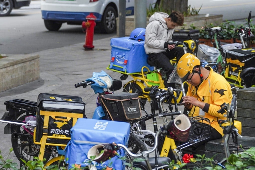 A Meituan Dianping delivery driver (front yellow) and a Ele.me delivery driver (back) sit on standby in the Futian district in Shenzhen. Photo: SCMP / Roy Issa