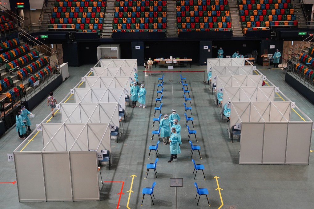 Medical staff wait outside cubicles set up as part of the coronavirus testing programme at Queen Elizabeth Stadium in Wan Chai. Photo: Sam Tsang