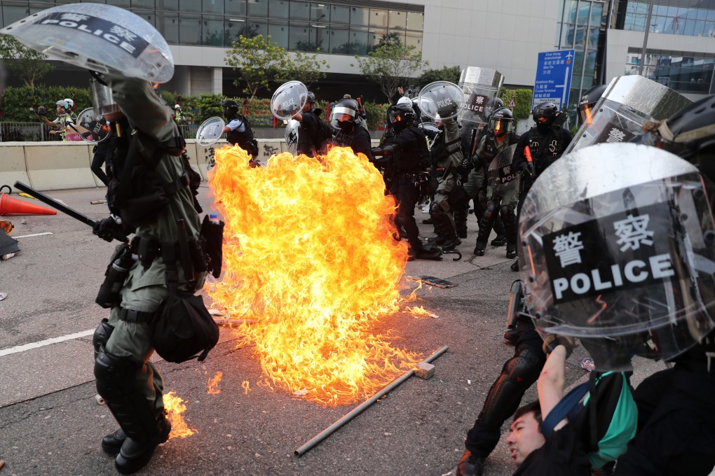 A petrol bomb lands near riot police during an anti-government protest in Hong Kong in August 2019. Photo: Sam Tsang