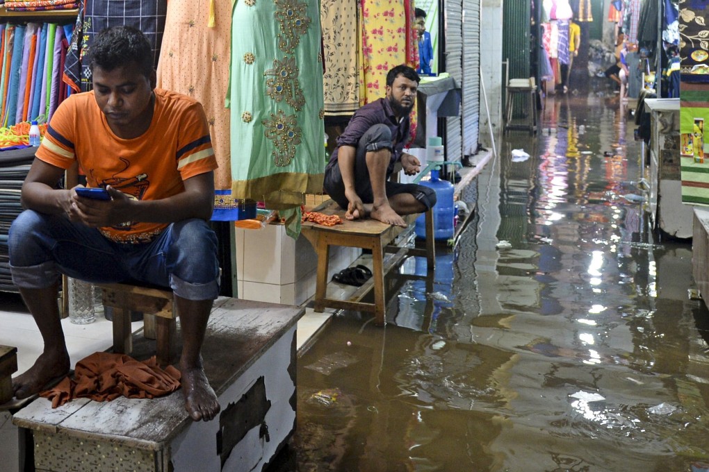 Shopkeepers wait for customers in a waterlogged shopping centre after a heavy downpour in Dhaka, Bangladesh, on July 21. Climate-change issues are rising on Asia’s economic and social agenda. Photo: AFP