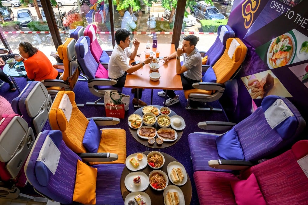 At a Thai Airways plane-themed pop-up restaurant at the airline’s headquarters, in Bangkok, would-be passengers eat “in-flight” meals served on plastic trays. Photo: AFP