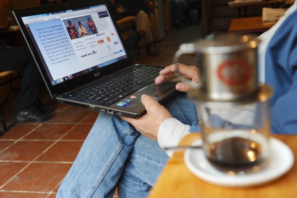 A man reads the news on his laptop in a coffee shop in Hanoi. About two thirds of Vietnam’s 97 million people are online and authorities are increasingly fixated on gauging public sentiment online. Photo: AFP