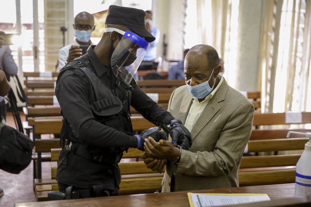 A policeman handcuffs Paul Rusesabagina (right) before leading him out of the Kicukiro Primary Court in the capital Kigali, Rwanda on Monday. Photo: AP