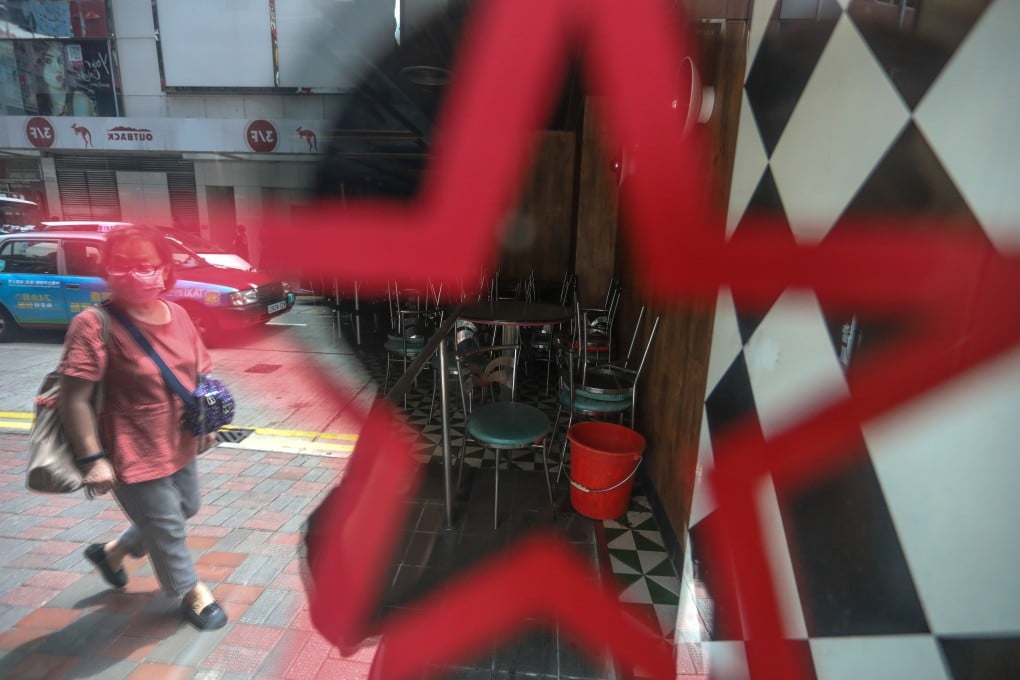 A woman walks past a closed restaurant in Causeway Bay, amid the third wave of coronavirus infections. Photo: Nora Tam