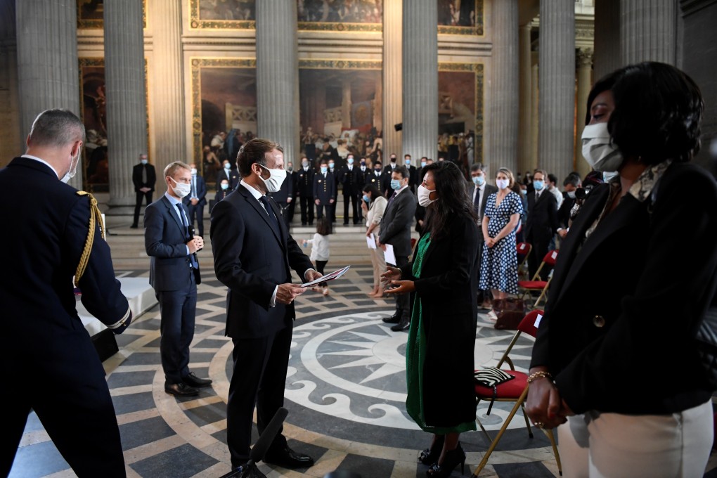 French President Emmanuel Macron hands over a Welcome to French Citizenship booklet to a new French citizen during a ceremony in Paris on September 4. The Interior Ministry on September 15 ordered regional officials to prioritise naturalisation requests from foreigners who “actively participated in the coronavirus effort”. Photo: Reuters