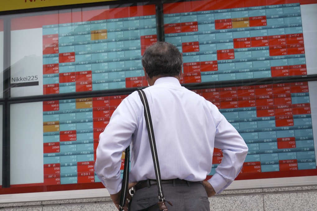 A man looks at an electronic stock board showing Japan's Nikkei 225 index at a brokerage firm in Tokyo, Japan. Photo: AP