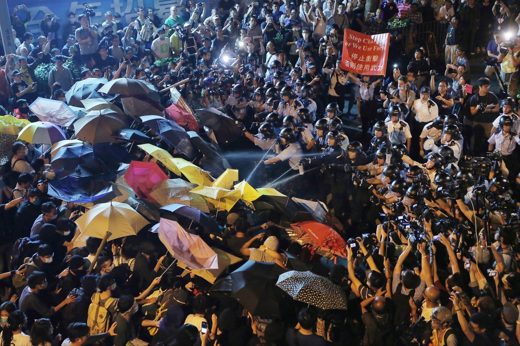 Hong Kong police pepper spray a crowd of protesters at an unlawful assembly outside Beijing’s liaison office on November 6, 2016. Photo: Paul Yeung
