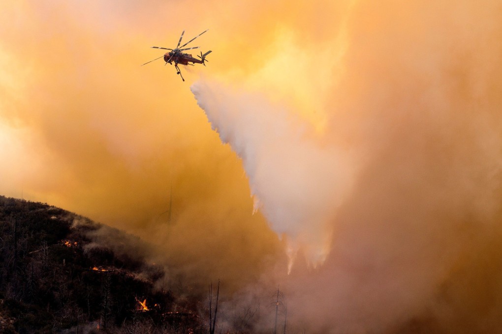 A helicopter makes a water drop over a wildfire in the Angeles National Forest during the Bobcat fire in Los Angeles, California. Photo: Reuters