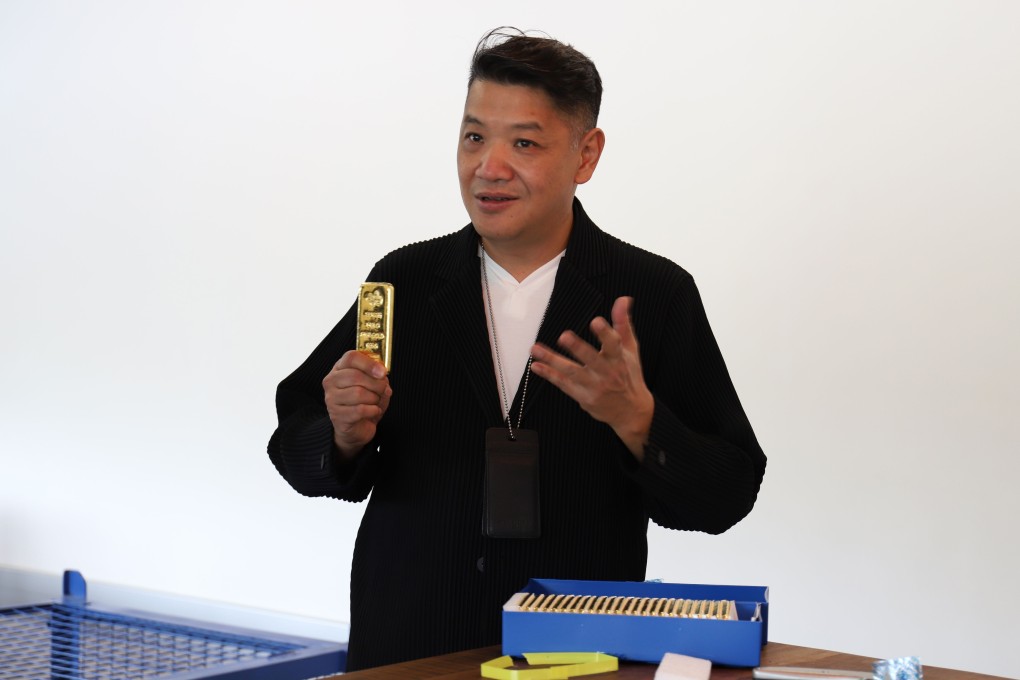 Victor Foo, CEO of the Singapore Precious Metals Exchange, holds a 1kg gold bar during a media tour at his office in Le Freeport. Photo: AFP