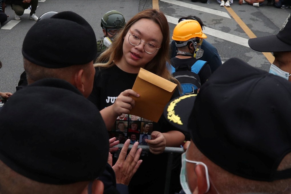 Student activist Panusaya Sithijirawattankul hands a demands letter to police on September 20, 2020. Photo: Reuters
