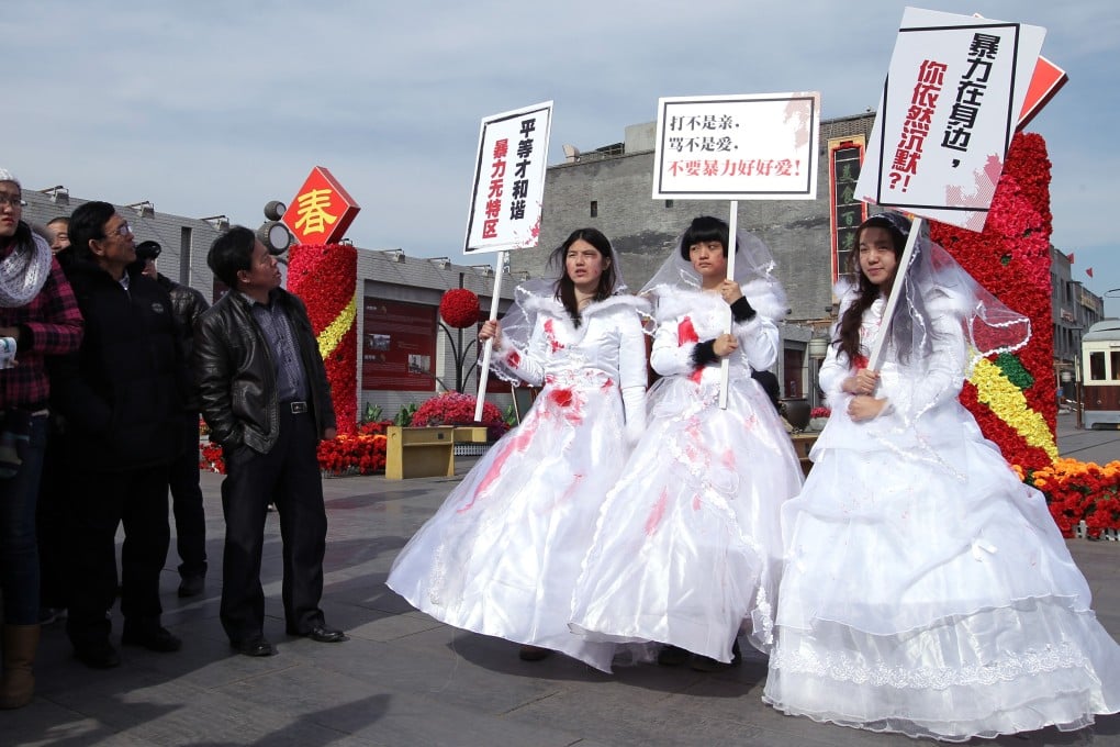Three women walk down Qianmen Avenue in Beijing in red-splattered wedding dresses to protest against domestic violence on February 14, 2012. Photo: Simon Song